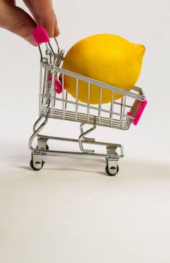 Beyaz bir arka planda market arabasında limon