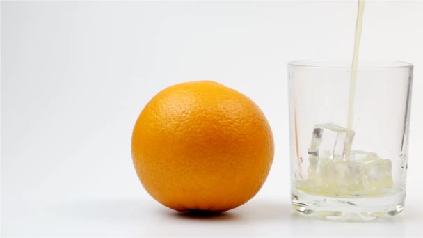 Χύνεται Χυμός Πορτοκαλιού Ποτήρι Και Ολόκληρο Πορτοκάλι Λευκό Φόντο — Αρχείο Βίντεο
