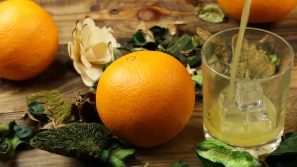 Apelsinjuice Hälls Ett Glas Ett Bord Med Blommor Och Apelsiner — Stockvideo