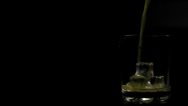 Portakal Suyu Siyah Zemin Üzerinde Buz Olan Bir Bardağa Dökülür — Stok video