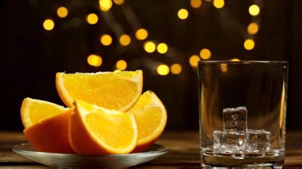 Rebanadas Naranja Plato Jugo Vierten Vaso Con Luces Fondo — Vídeos de Stock