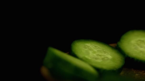 Salatalıklar Siyah Arkaplanda Bir Tabakta Dönerler — Stok video