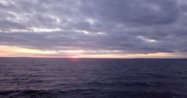 Bir uçuştan sonra geniş bir nehrin dalgaları üzerinde gün batımı