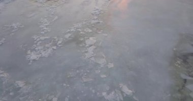 Gün batımında donmuş nehrin üzerinde uçmak