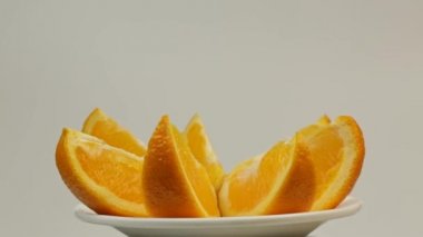 Beyaz bir tabakta dönen olgun tatlı portakal dilimleri