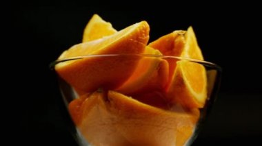 Tatlı olarak portakalı siyah arka planda cam tabakta döndür.