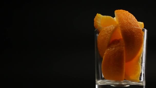 右側の黒の背景にガラスのオレンジのスライス — ストック動画