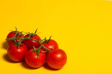 Sarı arka planda salata için kırmızı vişneli domates.