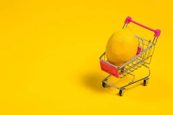 Gele Citroen Een Winkelwagen Een Gele Achtergrond Boodschappenkarretje — Stockfoto