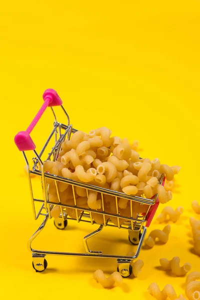 Pasta Een Winkelwagentje Een Gele Achtergrond — Stockfoto