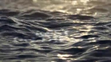The word REST ON THE SEA in the water at sunset, the word underwater