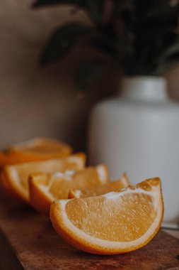 Portakallar ahşap konsol üzerinde dilimler. Beyaz vazo