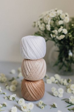 Cotton, flowers, needles, scissors, yarn, on a rustic background