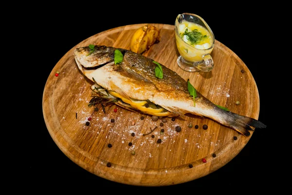 Grilled fish with lemon and spices on a wooden board — Stock Photo, Image