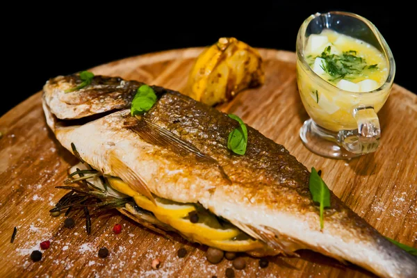 Grilled fish with lemon and spices on a wooden board — Stock Photo, Image