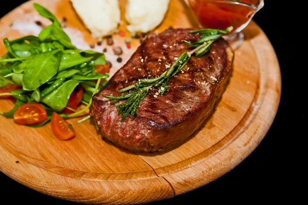 Gegrilde steak met aardappelen, salade en ketchup — Stockfoto