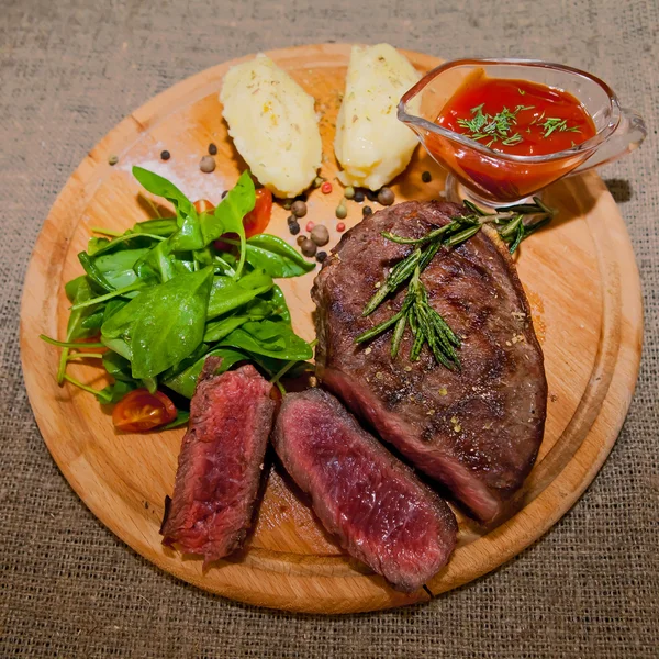 Gegrilde steak met aardappelen, salade en ketchup — Stockfoto