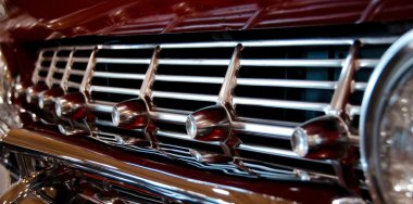 Chrome front grill of a classic bordeaux car
