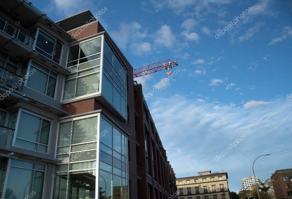 Grúa detrás de un moderno edificio de apartamentos en Pandora junto al