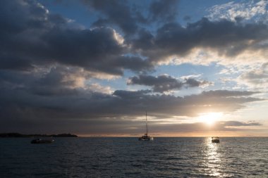 Anaehoomalu Körfezi, Büyük Ada, Hawaii 'deki teknenin üzerinde gün batımı vurgulanıyor