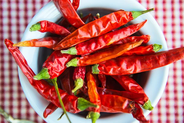 Små vita lergryta full av dryed chili peppers Stockfoto