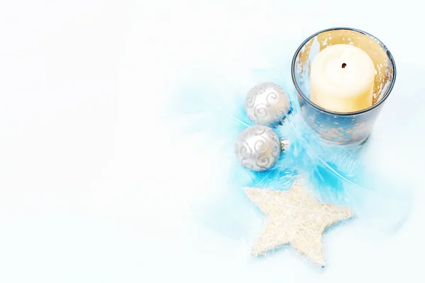 Decoración de Navidad: vela cremosa y estrella, con bolas de plata y plumas . —  Fotos de Stock