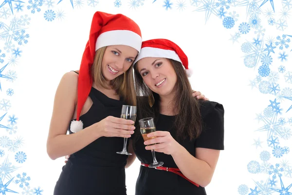 Happy girls in santa hats with champagne — Stockfoto