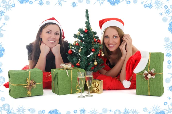 Duas garotas de chapéu de Papai Noel com presentes — Fotografia de Stock