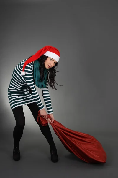 Mulher atraente no chapéu de Papai Noel com saco — Fotografia de Stock