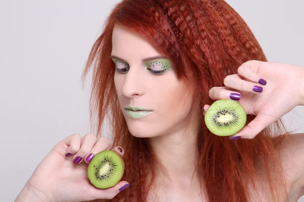 Attractive redhaired woman with kiwi — Stock Photo, Image