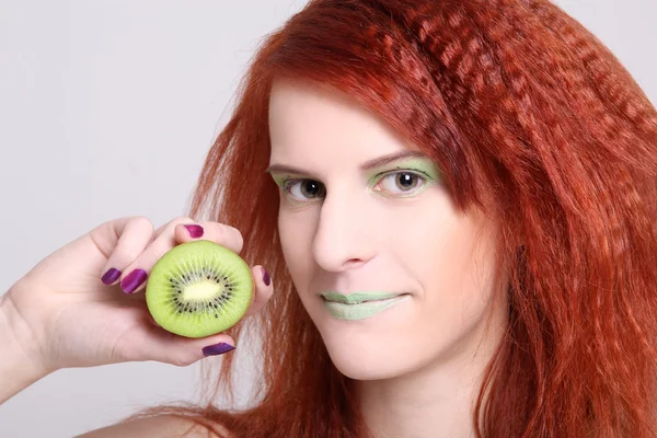 Redhaired atractiva mujer con kiwi sobre blanco — Foto de Stock