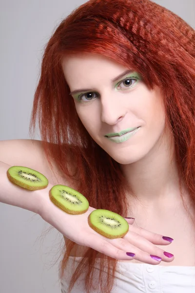 Young redhaired girl with kiwi slices — Stock Photo, Image