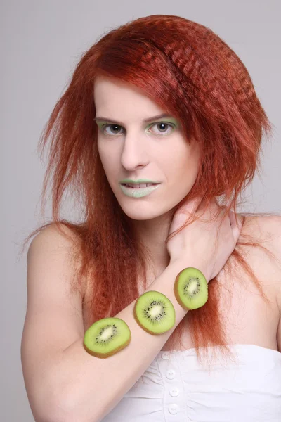 Redhaired girl with kiwi slices on her hand — Stock Photo, Image