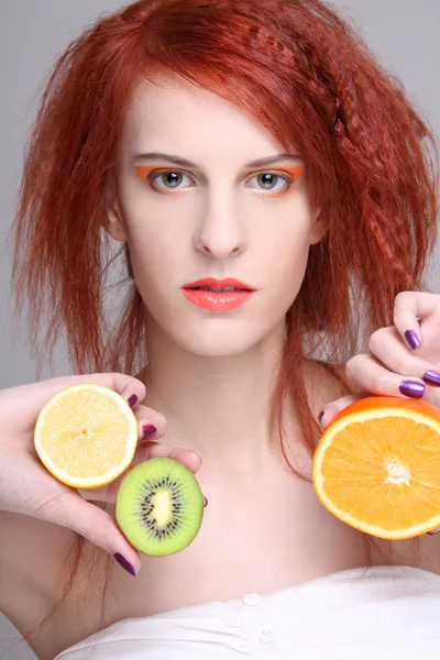 Redhaired κορίτσι με πορτοκάλι, λεμόνι και ακτινίδιο — Φωτογραφία Αρχείου