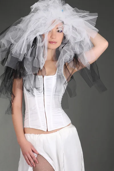 Woman in white dress with material on head posing Stock Picture