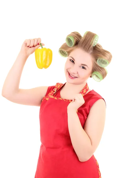 Jonge mooie huisvrouw met haar krulspelden en gele peper — Stockfoto
