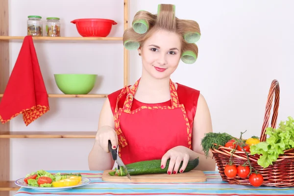 Pepino de corte jovem dona de casa na cozinha — Fotografia de Stock