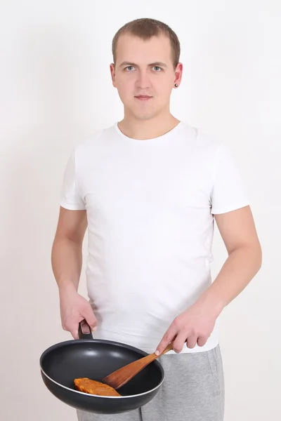 Ung man matlagning över vita — Stockfoto