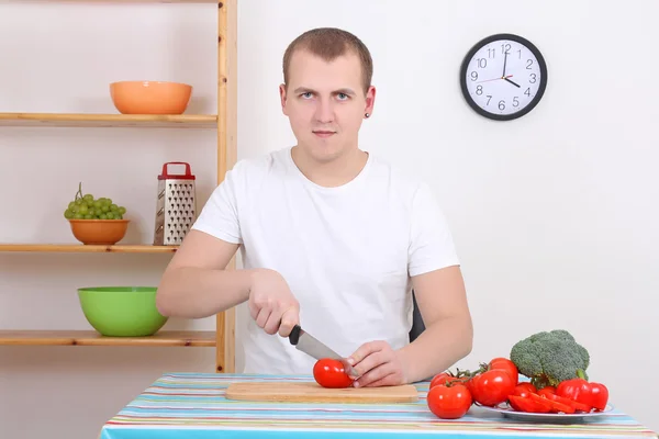 Man cutting tomato in the kitchen — Stock Photo, Image