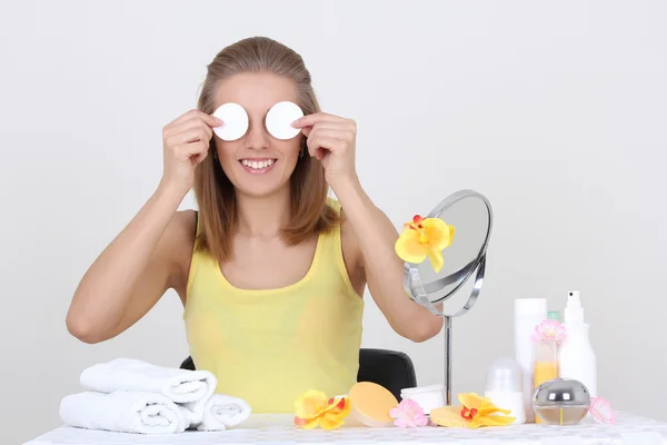 Vrouw zitten aan tafel met make-up accessoires en spiegel — Stockfoto