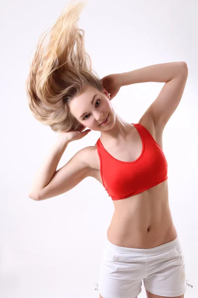 Sportiva donna con i capelli lunghi soffiando sopra bianco — Foto Stock