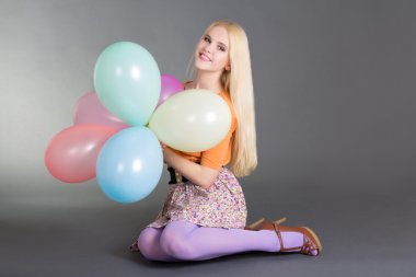 Balonlu gri adam üzerinde oturan genç çekici kadın