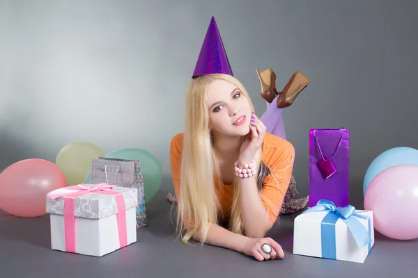 Mujer hermosa joven con globos miente sobre gris — Foto de Stock