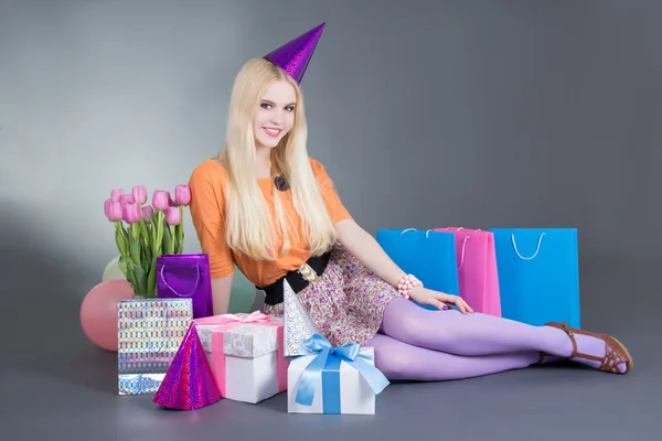 Portrait of beautiful blondie girl with gifts and flowers — Stock Photo, Image
