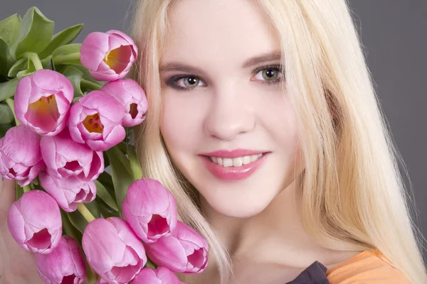 Aantrekkelijke blondie meisje met tulpen — Stockfoto