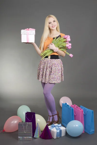 Portrait of beautiful blondie girl with gifts and flowers — Stock Photo, Image