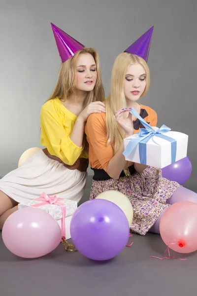 Girls sitting with gifts and colorful balloons — Stock Photo, Image