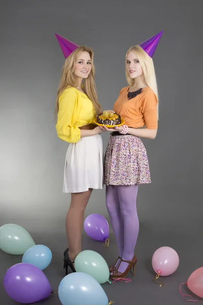 Beautiful girls with cake at a birthday party — Stock Photo, Image