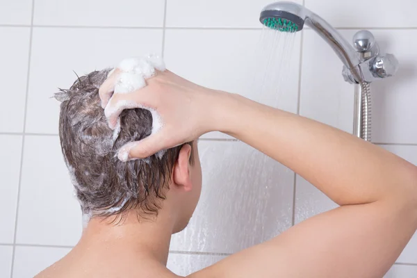 Jeune homme prenant une douche — Photo