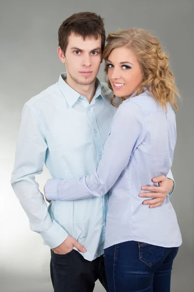 Portrait of young couple over grey — Stock Photo, Image